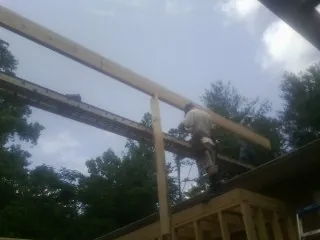 Carpenter setting a ridge beam over a new addition frame — Ice Dam Removal by Roofing Brothers in Wenatchee