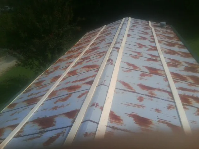 Rusted metal roof panels with new wood purlins before replacement — Storm Damage Roof Repair in Wenatchee by Roofing Brothers